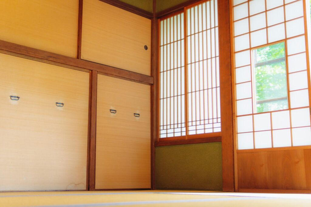an empty room with wooden doors and windows