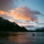 Mountains at sunset with colorful clouds over water